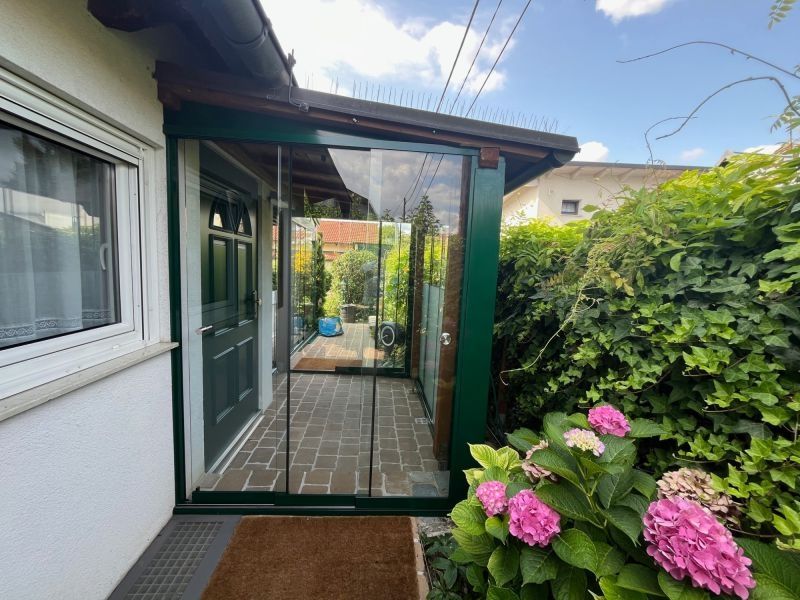 Nurglas-Schiebewänden an einer Pergola aus Holz von der Seite