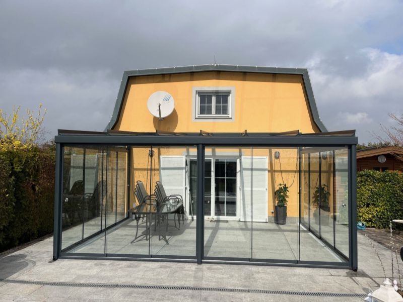 Vacanza Dach Sommergarten an einem gelb verputzten Haus