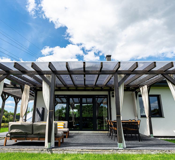 Terrassenüberdachung aus Holz mit Dekovorhängen